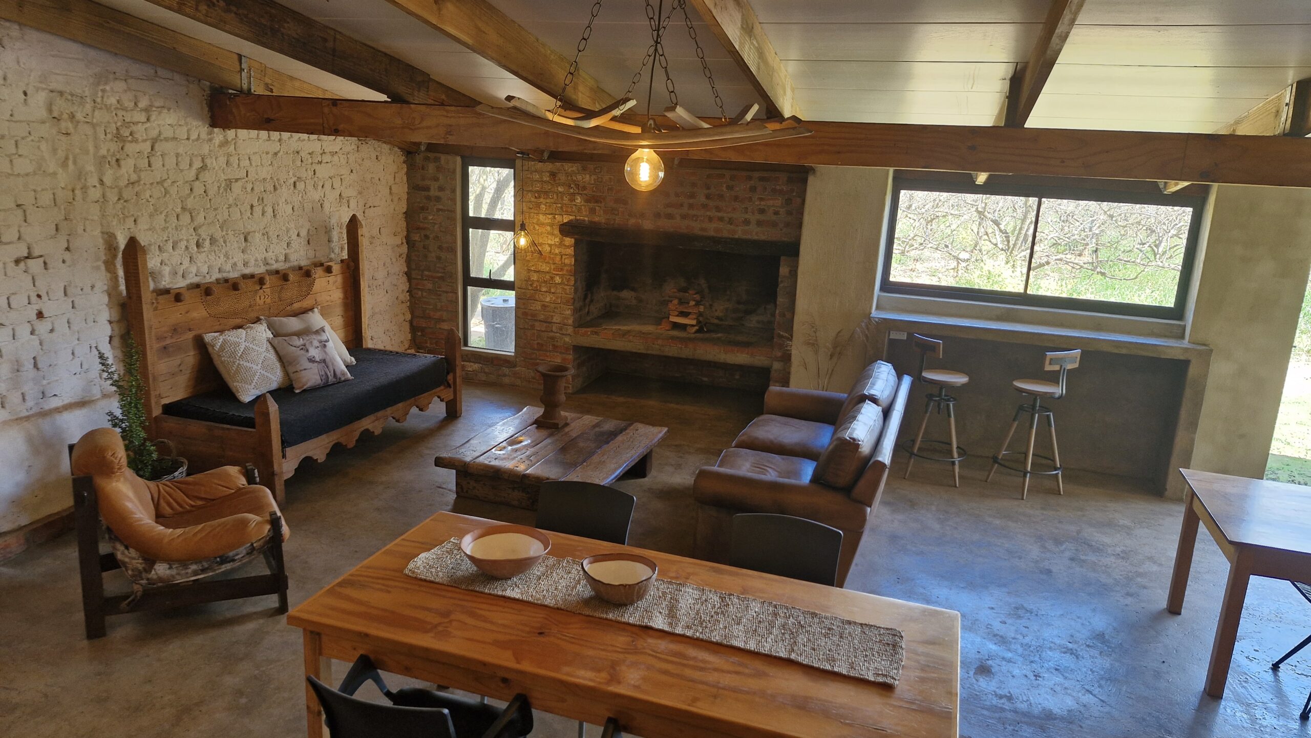 Rustic Living Area with Fireplace and Wooden Decor Rustic and cozy living area with wooden furniture, bar stools, and a fireplace.